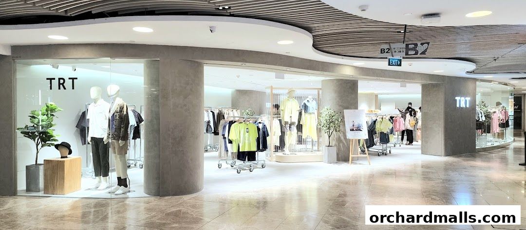 The TRT Singapore Wheelock Place shop features a modern interior with mannequins and clothing displays.