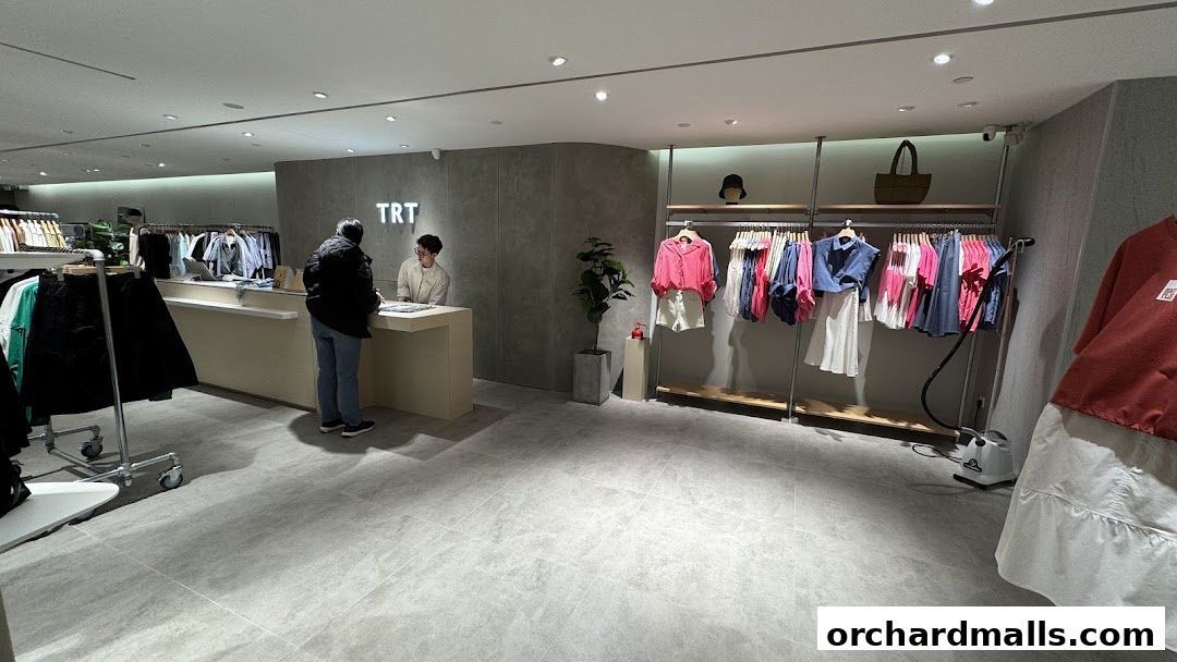 Interior of a clothing store with racks of apparel and a checkout counter.