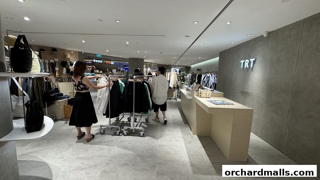 Interior of a clothing store with racks of clothes and a checkout counter.