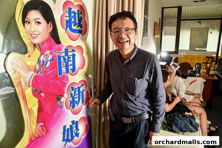 A man stands next to a cutout of a bride, with other women in the background.