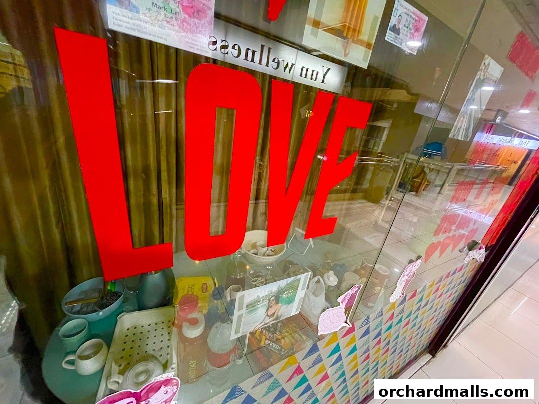 Shop window with large red 'LOVE' lettering and various items displayed inside.
