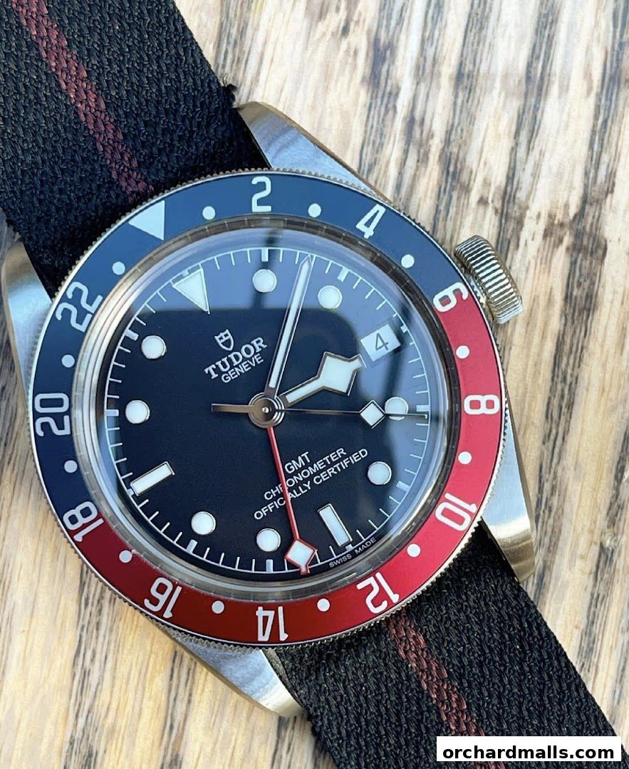 Close-up of a Tudor GMT watch with a black dial and red and blue bezel.