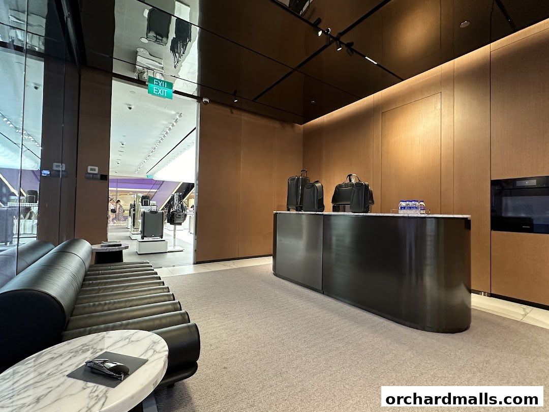 Interior of a TUMI store with luggage on display and a reception counter.
