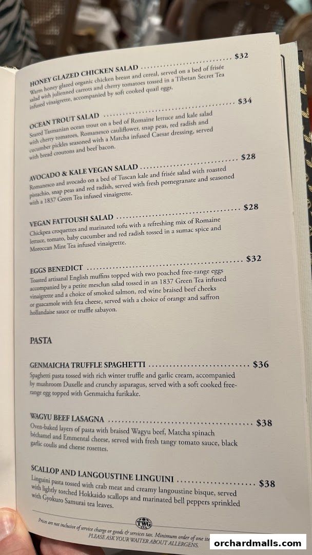 A menu from TWG Tea featuring salads, pasta dishes, and other entrees with prices.