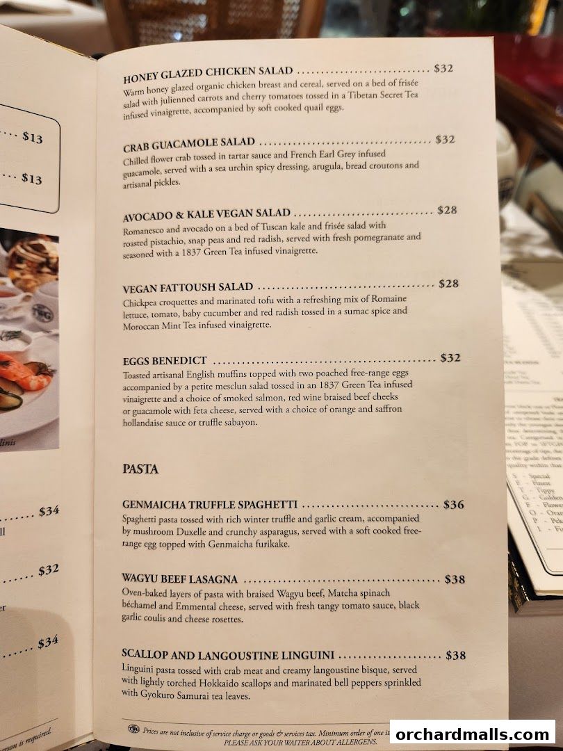 A menu from TWG Tea featuring salads, pasta dishes, and other entrees with prices.