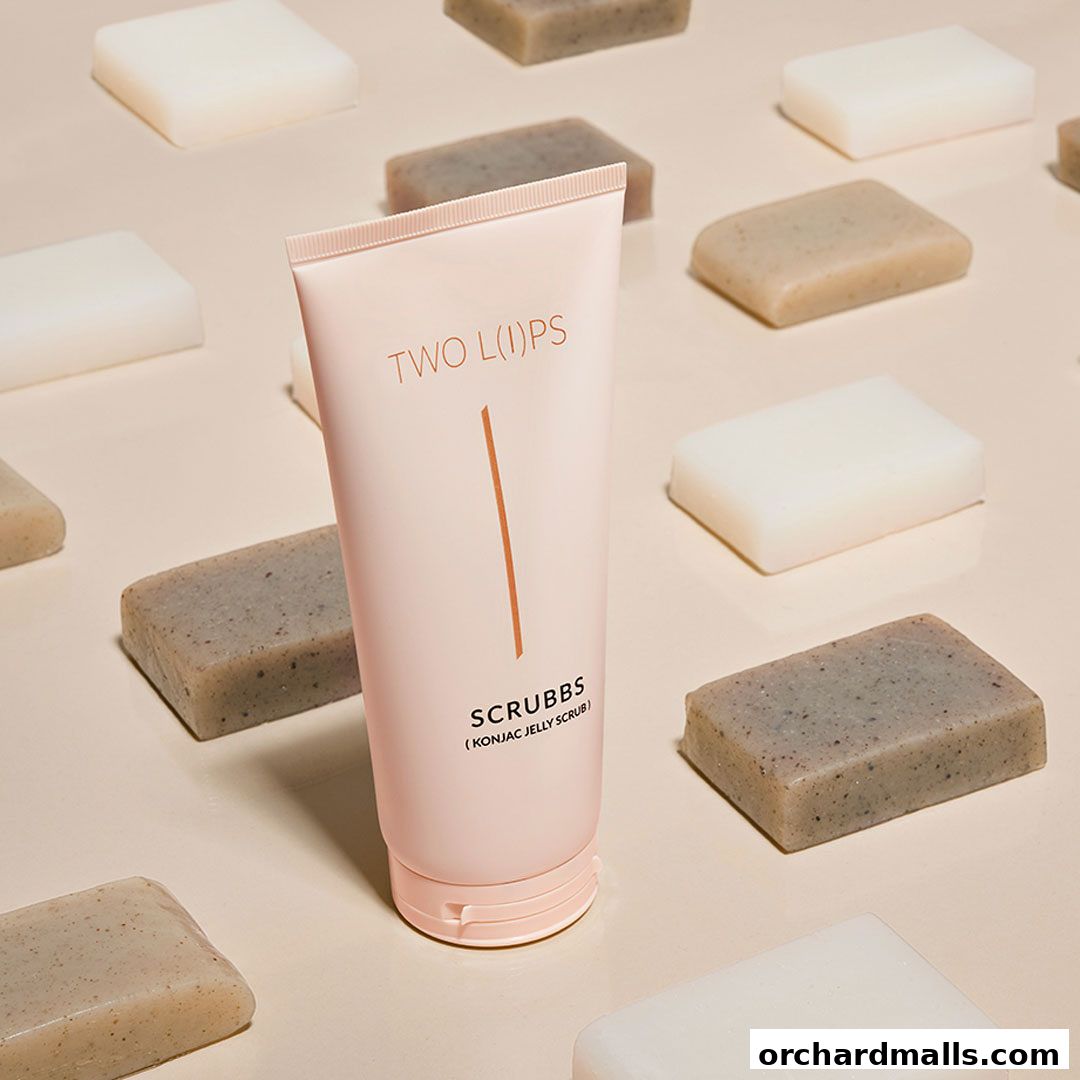 A pink tube of 'SCRUBBS (KONJAC JELLY SCRUB)' by TWO LIPS surrounded by various soaps.