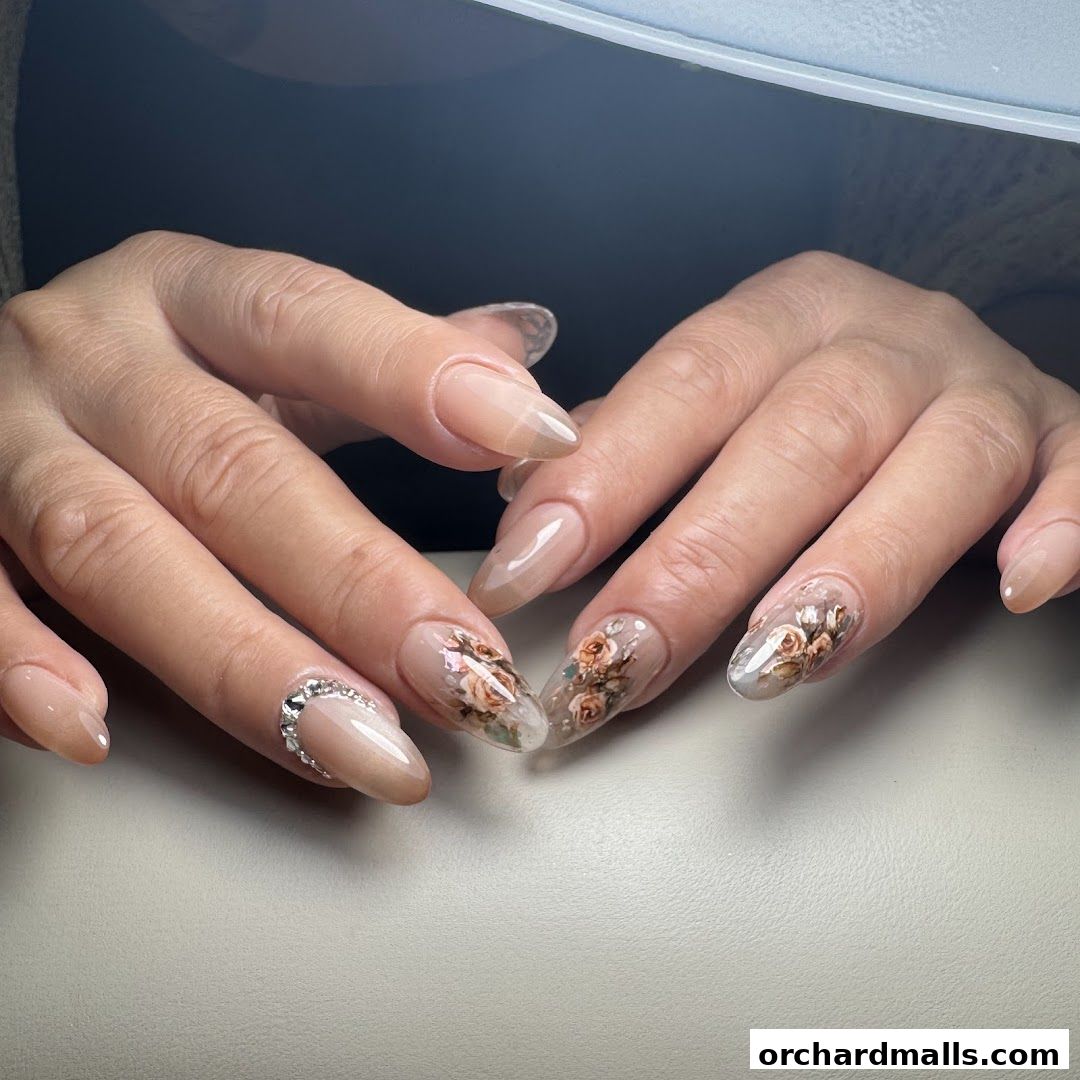 Close-up of hands with elegant, floral-designed almond-shaped nails.