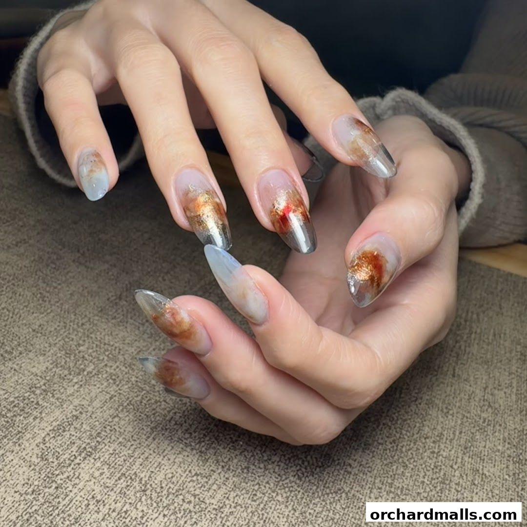 Close-up of hands with intricate, artistic nail designs featuring abstract patterns and metallic accents.