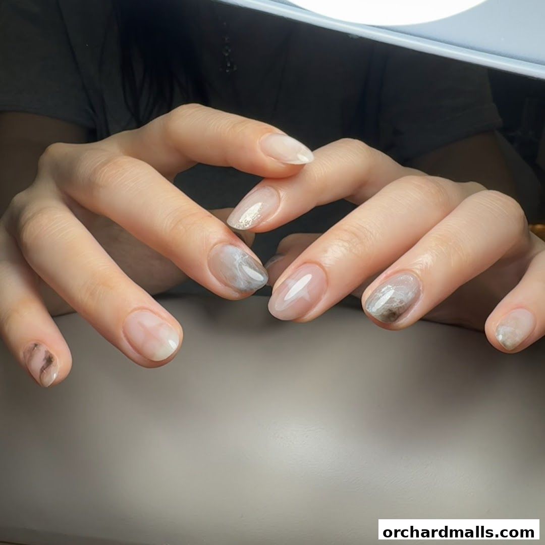 Close-up of hands with beautifully designed marble-effect and glitter nail art.