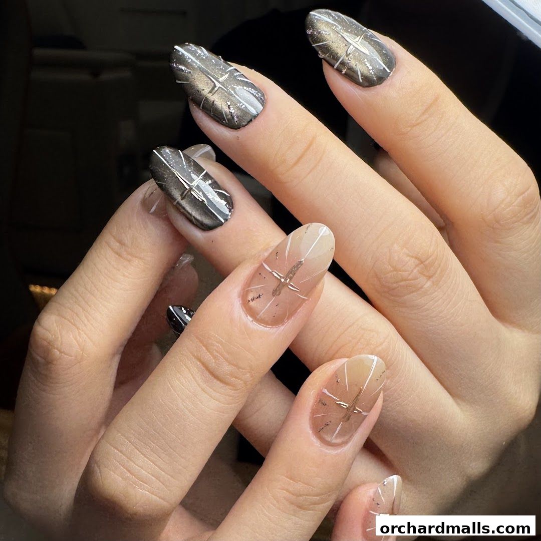 Close-up of hands with intricate nail art featuring metallic and gradient designs.