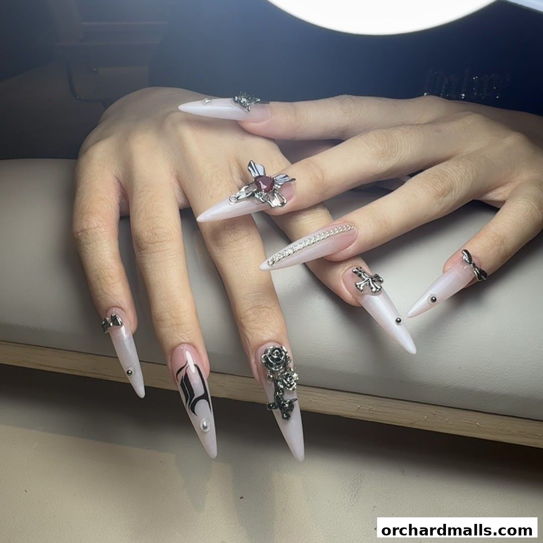 Close-up of hands with elaborate, long, stiletto-shaped nails adorned with charms.