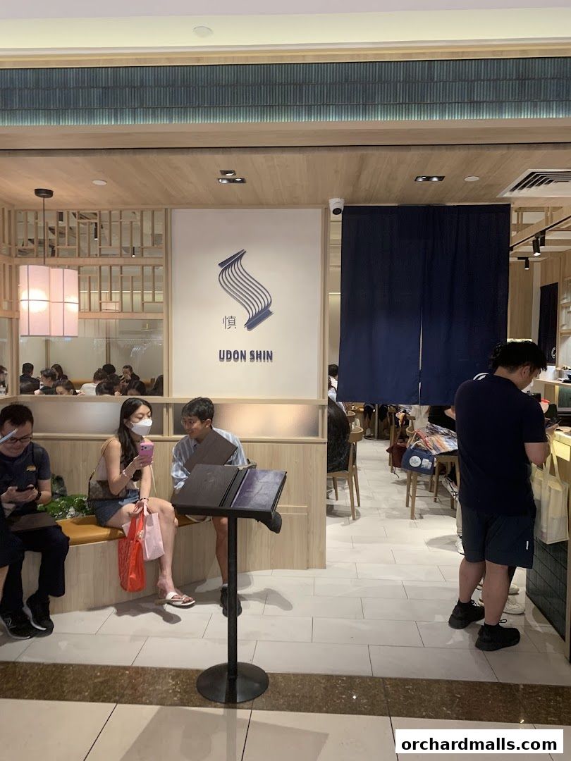 Interior of Udon Shin Singapore restaurant with customers and staff.