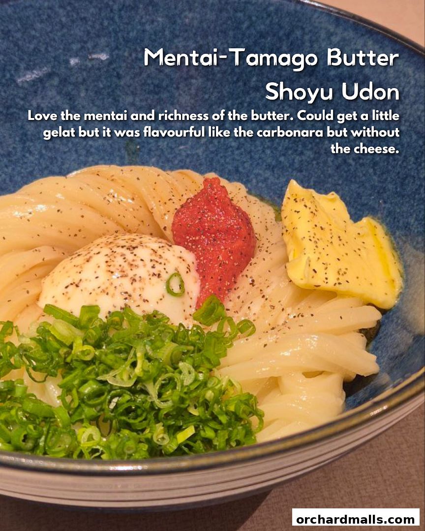 A close-up of Mentai-Tamago Butter Shoyu Udon with mentai, egg, butter, and green onions.