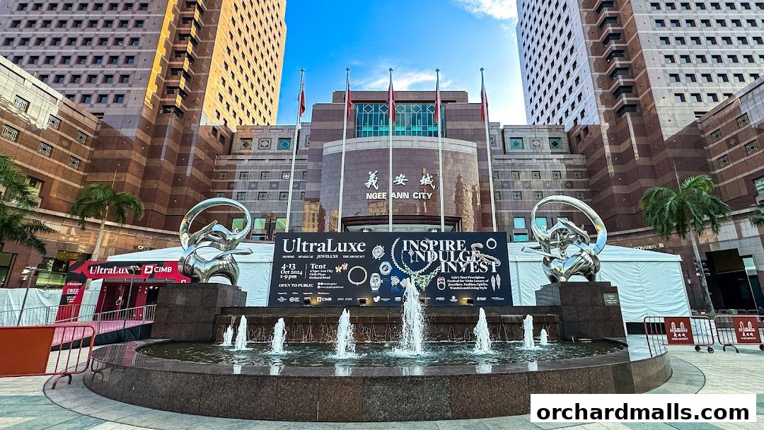 Ngee Ann City plaza with a fountain, sculptures, and a banner for UltraLuxe.