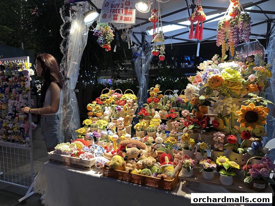 A stall displays a vibrant collection of handmade crochet flowers and plush toys.