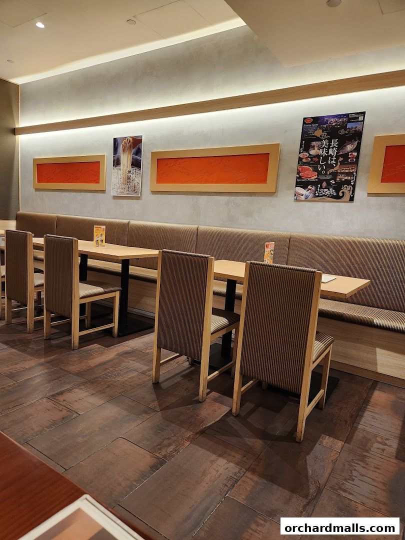 Interior of a restaurant with tables, chairs, and decorative wall art.