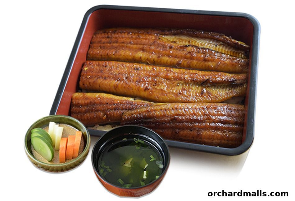 A bento box filled with grilled eel, served with pickles and soup.