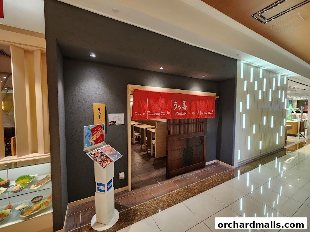 The entrance to Unazen, a Japanese restaurant, with a red noren curtain and a display stand.