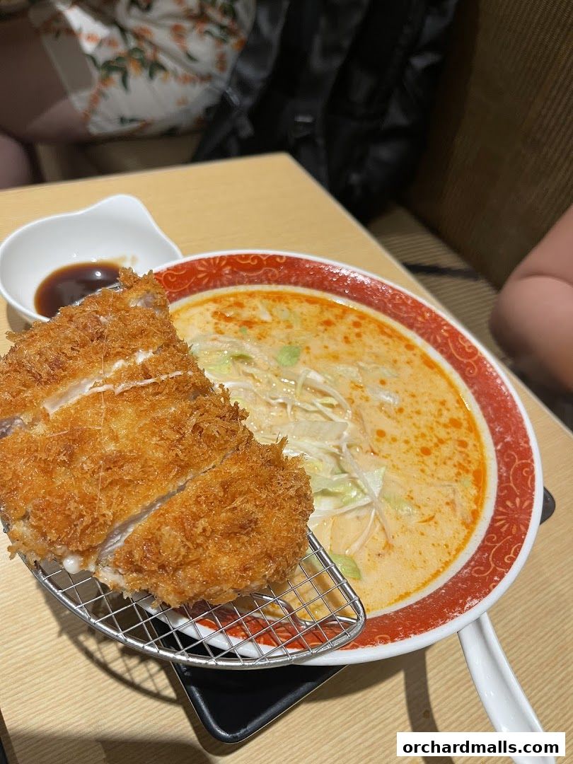 A close-up of a crispy tonkatsu served with a bowl of ramen at Unazen.