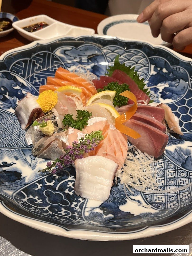 A platter of assorted sashimi with salmon, tuna, octopus, and white fish.