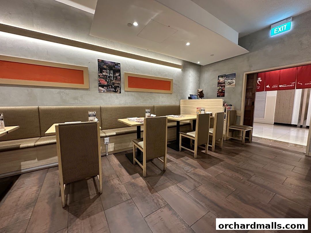 Interior view of a Japanese restaurant with seating, tables, and an exit sign.