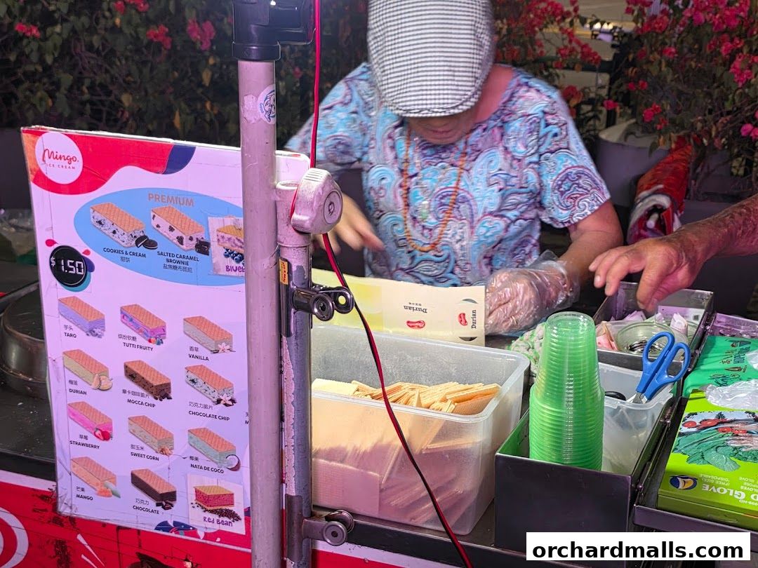 A vendor prepares wafer ice cream with a variety of flavors displayed on a menu.