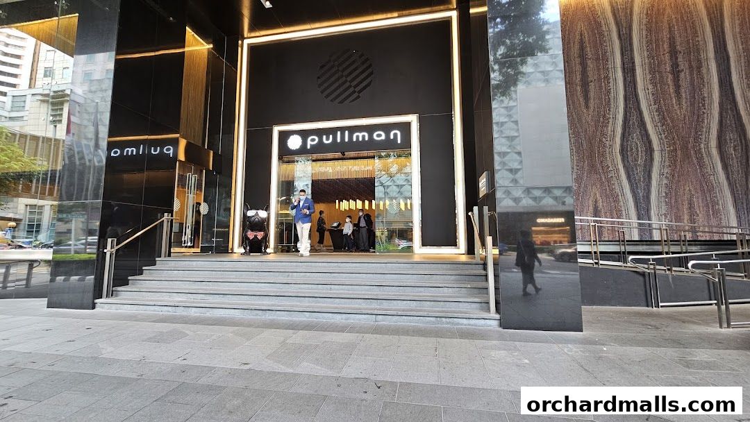 The entrance to the Pullman hotel with a modern facade and decorative elements.