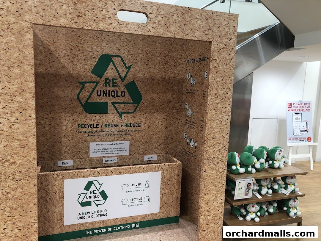 Uniqlo store display featuring a clothing recycling bin and Doraemon plush toys.