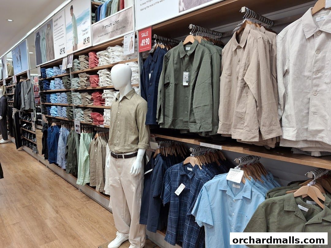 Interior view of a UNIQLO store showcasing men's linen shirts and apparel on display.