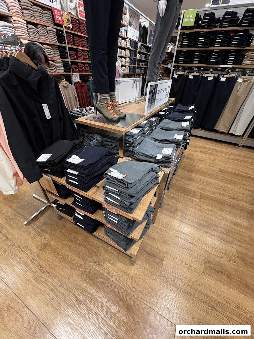 Interior view of a UNIQLO store showcasing folded pants and mannequins with new arrivals.