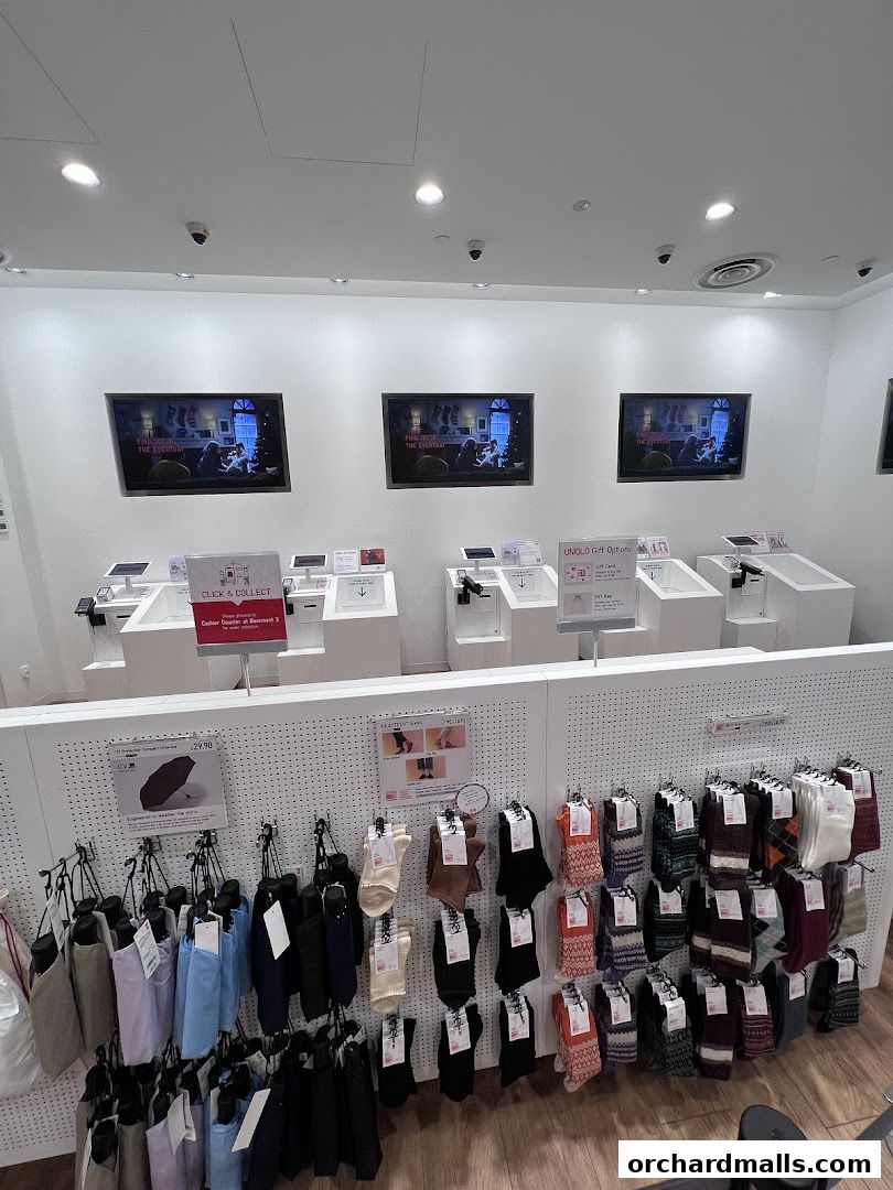 UNIQLO store interior showcasing click and collect service and various apparel items like socks and umbrellas.