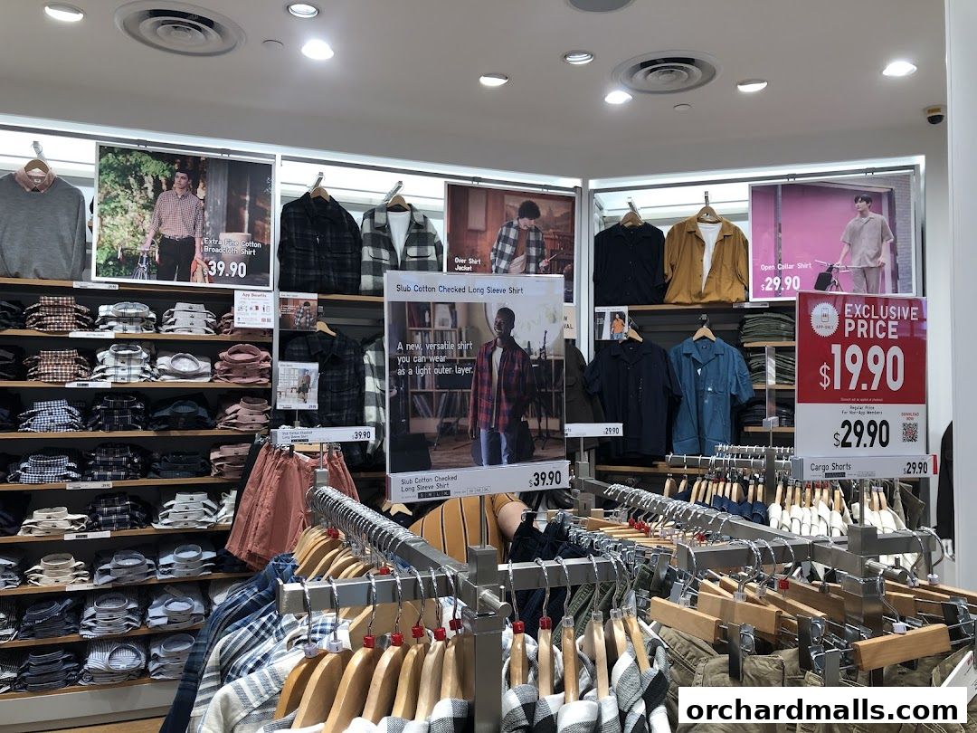 Interior view of a UNIQLO store showcasing various shirts and shorts with promotional pricing.