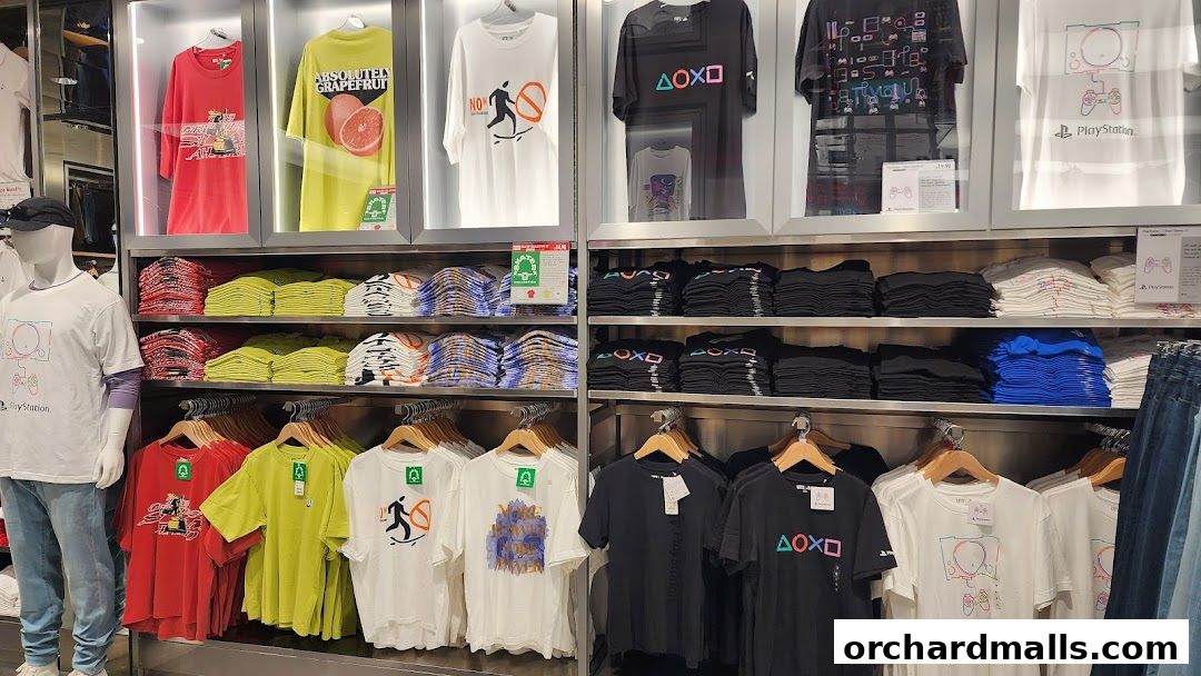 A display of graphic t-shirts, including PlayStation designs, neatly folded and on hangers.