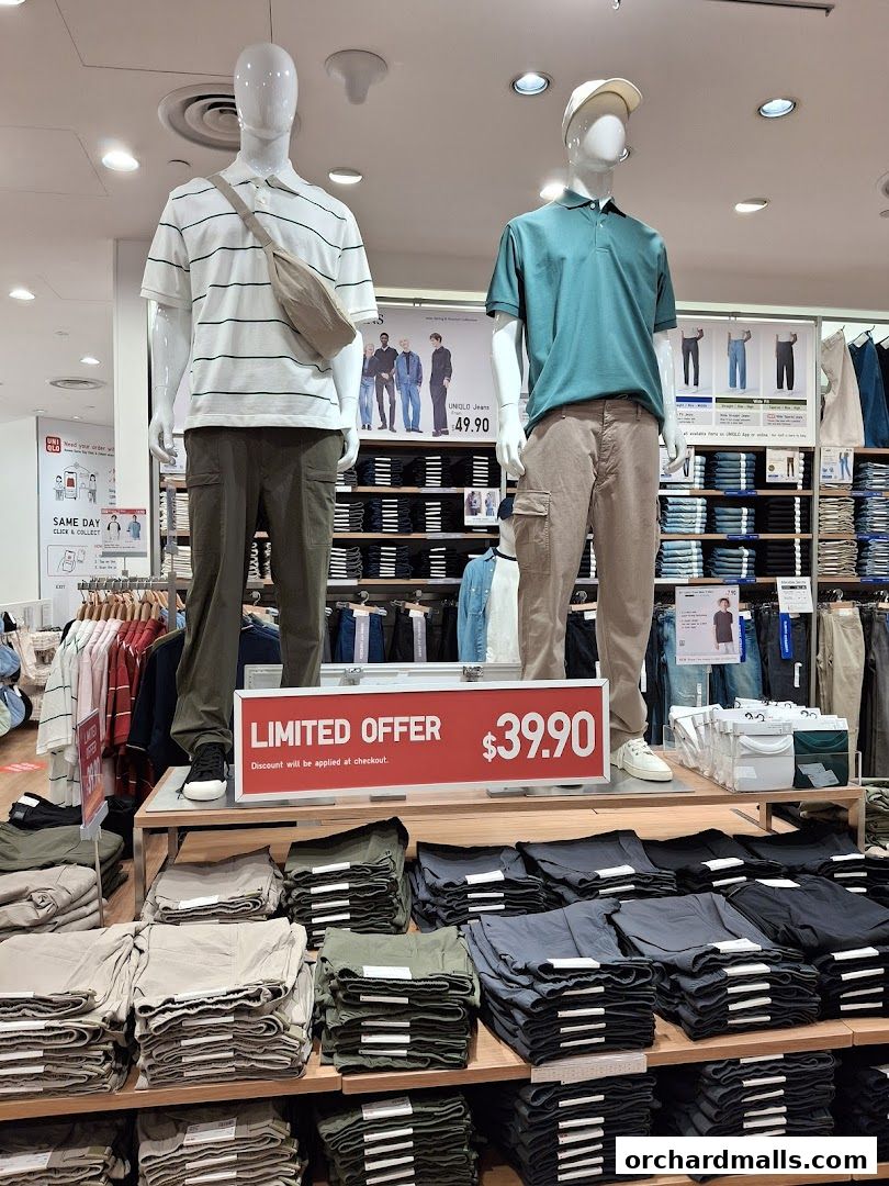 Mannequins display Uniqlo outfits with a limited offer sign and folded pants.