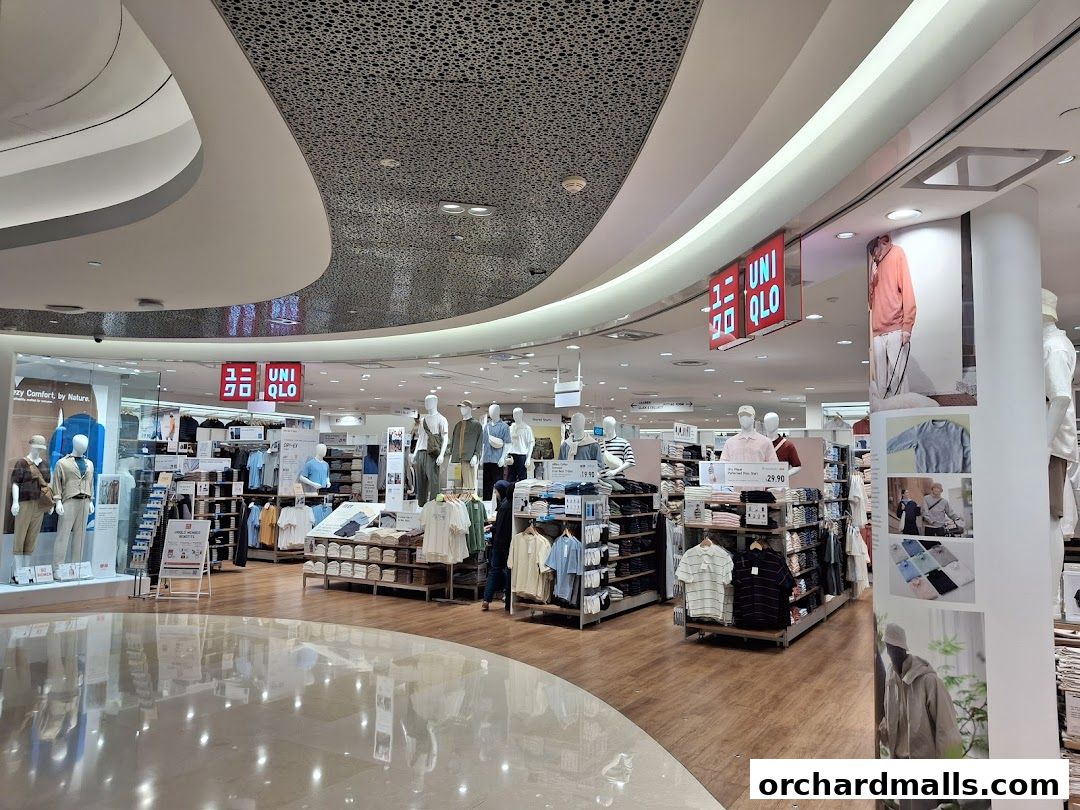 Interior view of a brightly lit Uniqlo store showcasing clothing on mannequins and shelves.