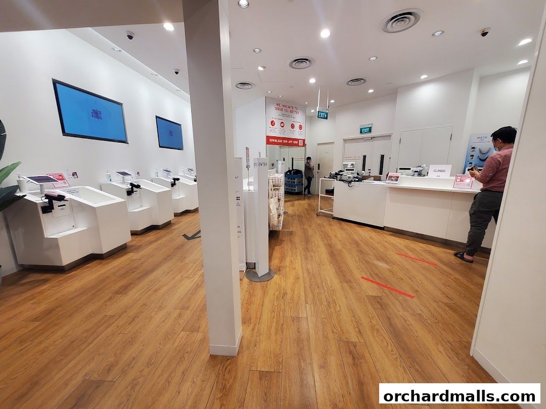 Interior of a Uniqlo store with self-checkout stations and a service counter.
