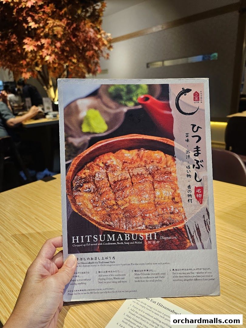 A person holds a menu featuring a signature Hitsumabushi dish from UYA Unagi Singapore.