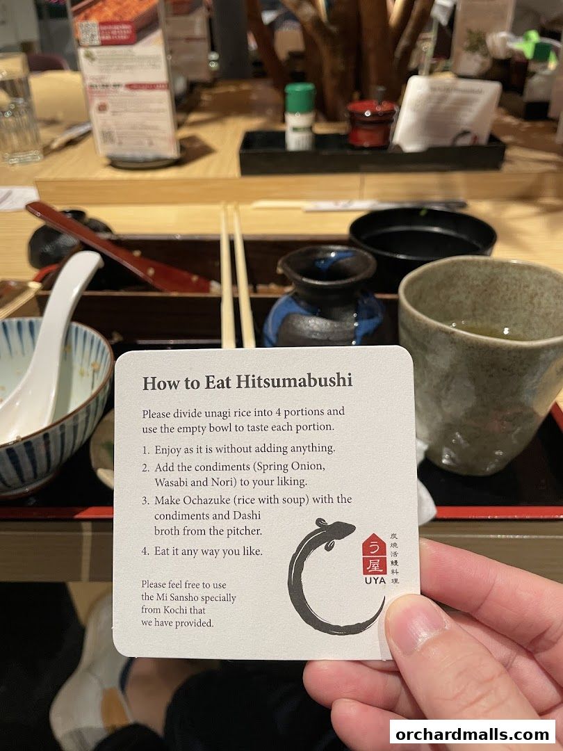 A guide on how to eat Hitsumabushi is held up at a table setting.