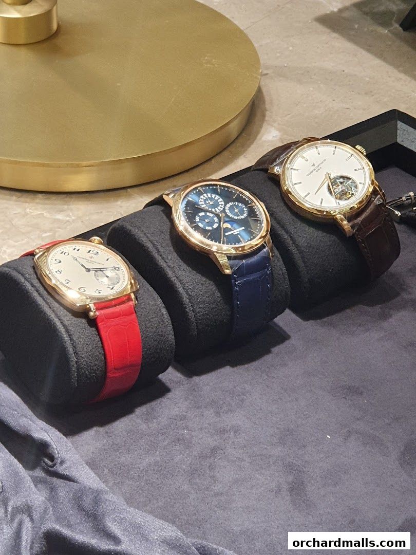 Three luxury Vacheron Constantin watches displayed on black stands with elegant straps.