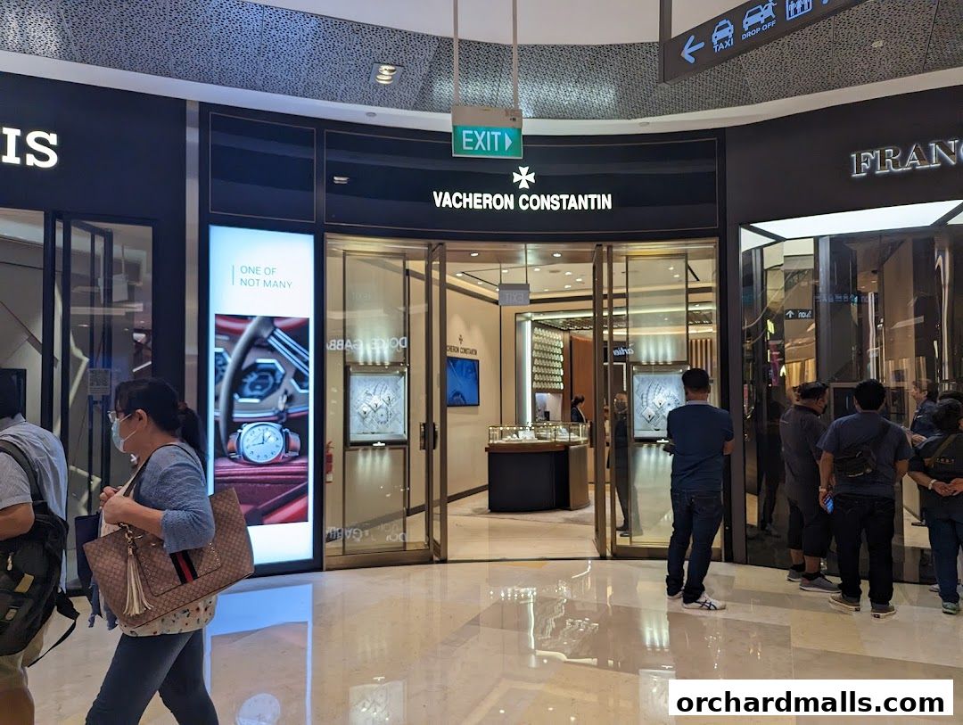 The entrance of a Vacheron Constantin watch store with people browsing inside and outside.