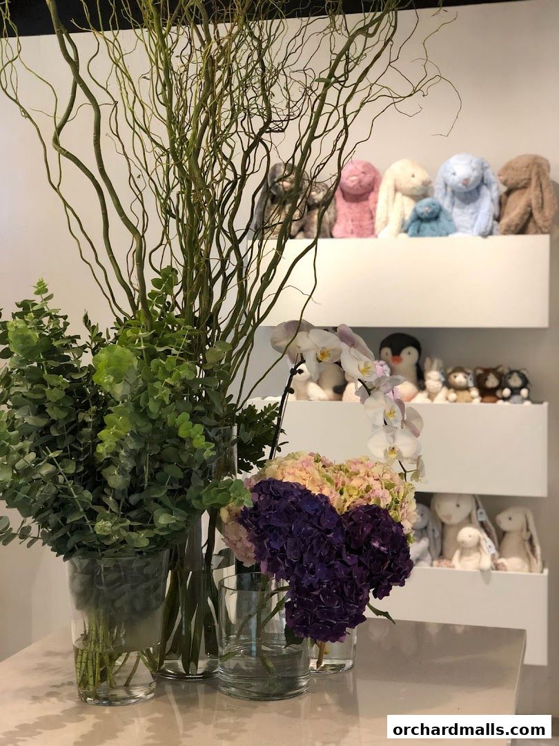 A display of fresh flowers and plush toys on shelves in a shop.