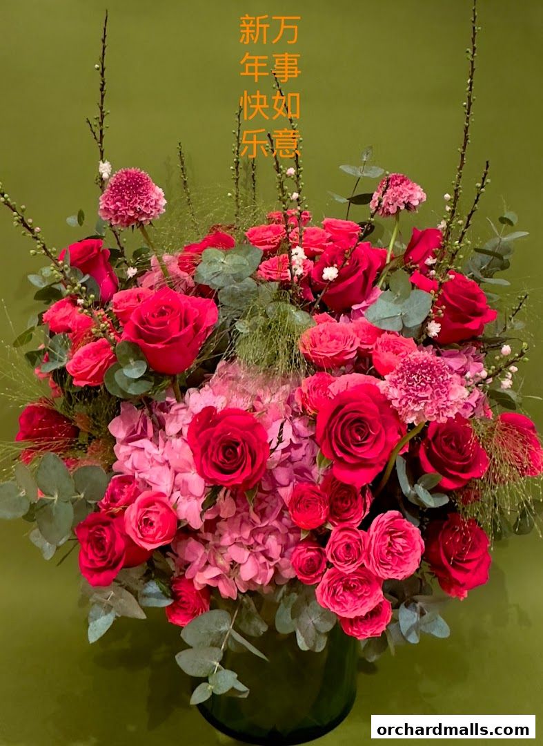A vibrant bouquet of red and pink roses and hydrangeas with eucalyptus leaves.