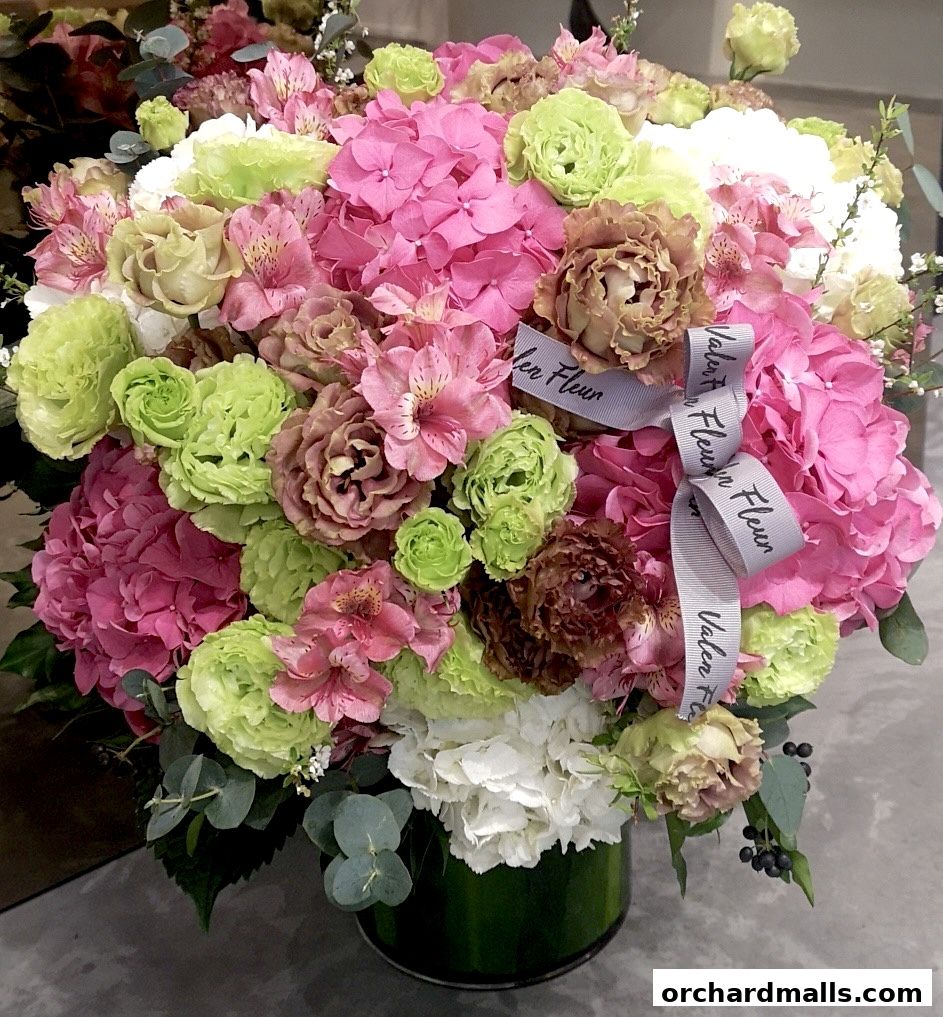 A vibrant bouquet of pink, green, and brown flowers with a ribbon that says 'Valen Fleur'.