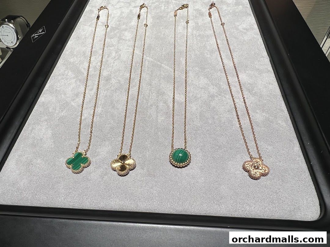 A display of Van Cleef & Arpels Alhambra necklaces with malachite and gold.