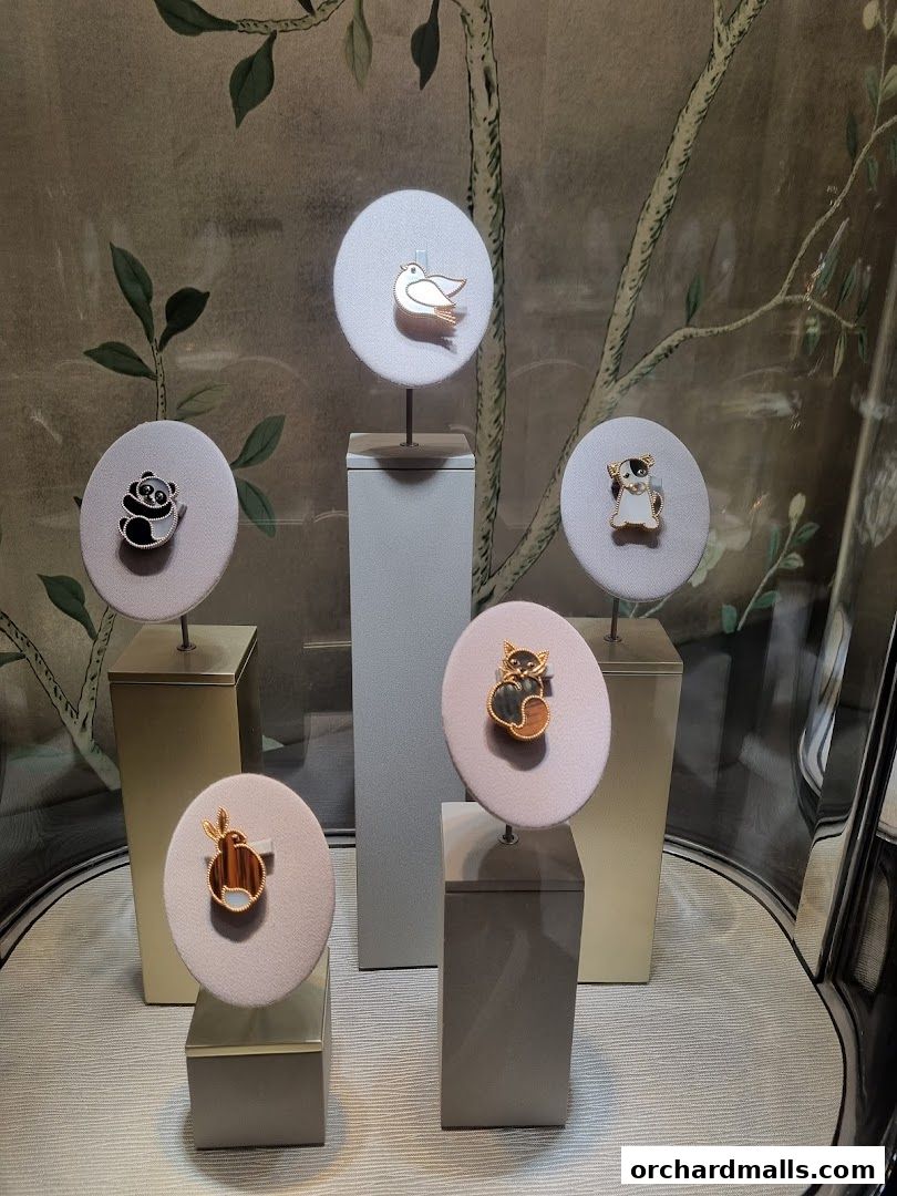 A display of charming animal-themed brooches on stands in a shop window.