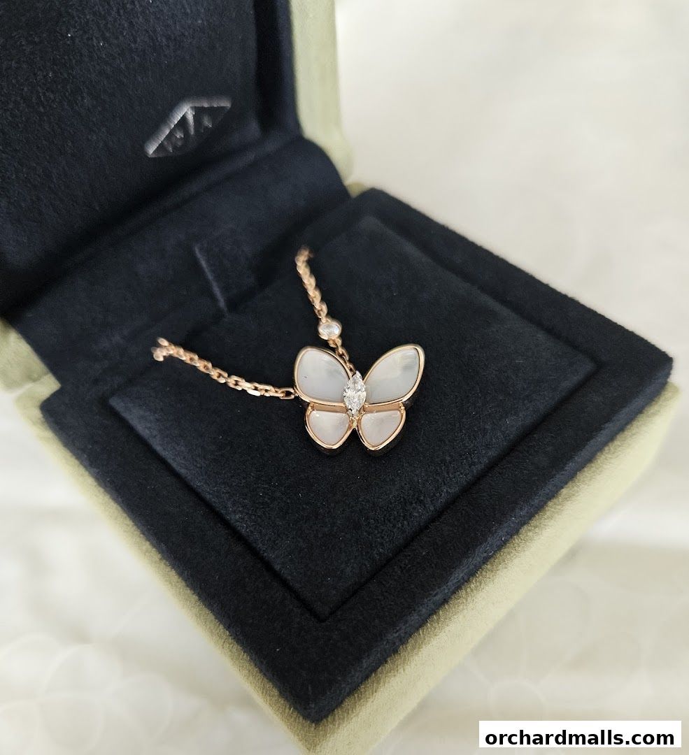 A close-up of a Van Cleef & Arpels Alhambra butterfly necklace in a jewelry box.