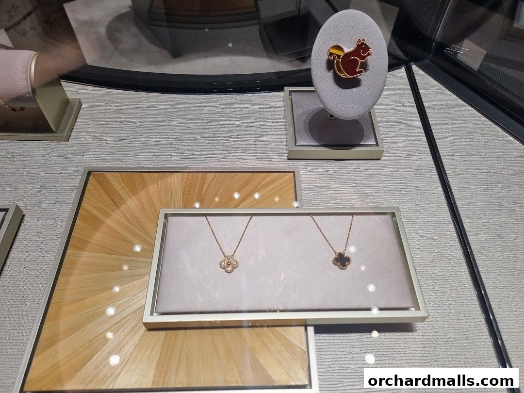 A display case showcasing Van Cleef & Arpels necklaces and a squirrel-themed brooch.