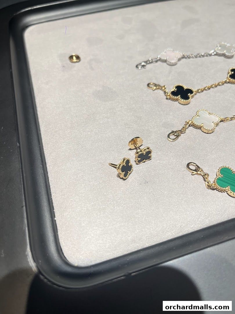 Close-up of Van Cleef & Arpels Alhambra jewelry, featuring earrings and bracelets with clover motifs.