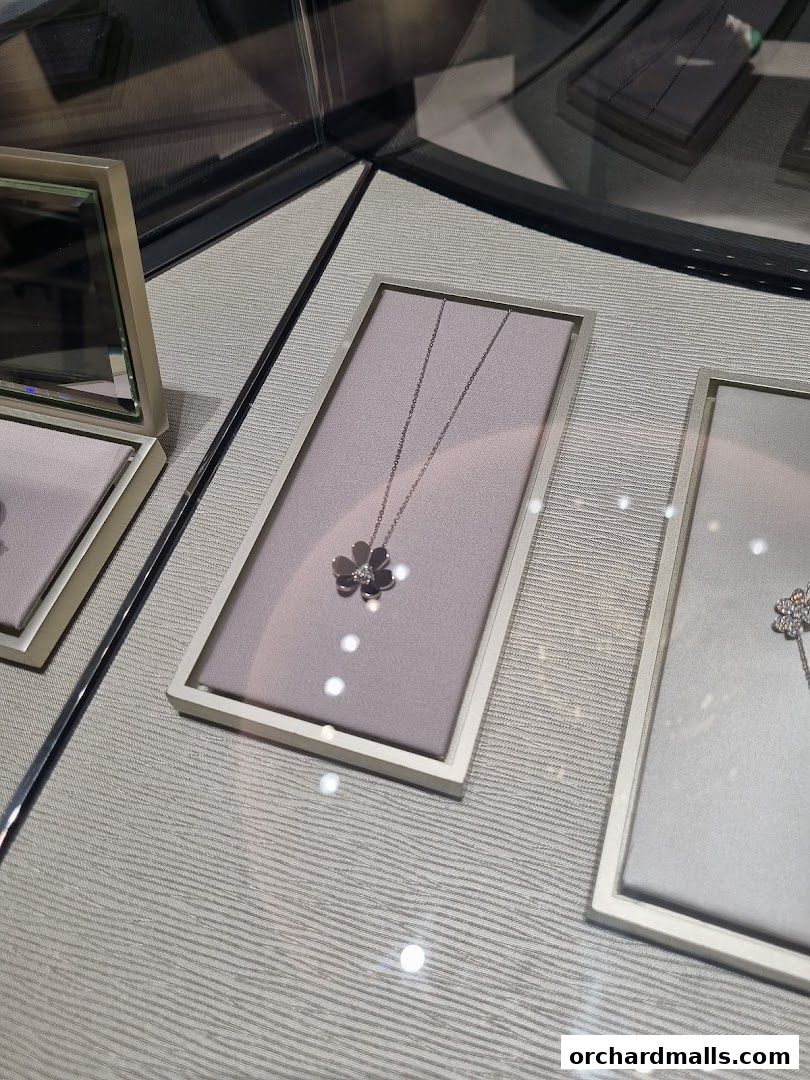 A close-up view of Van Cleef & Arpels necklaces displayed in a jewelry store window.