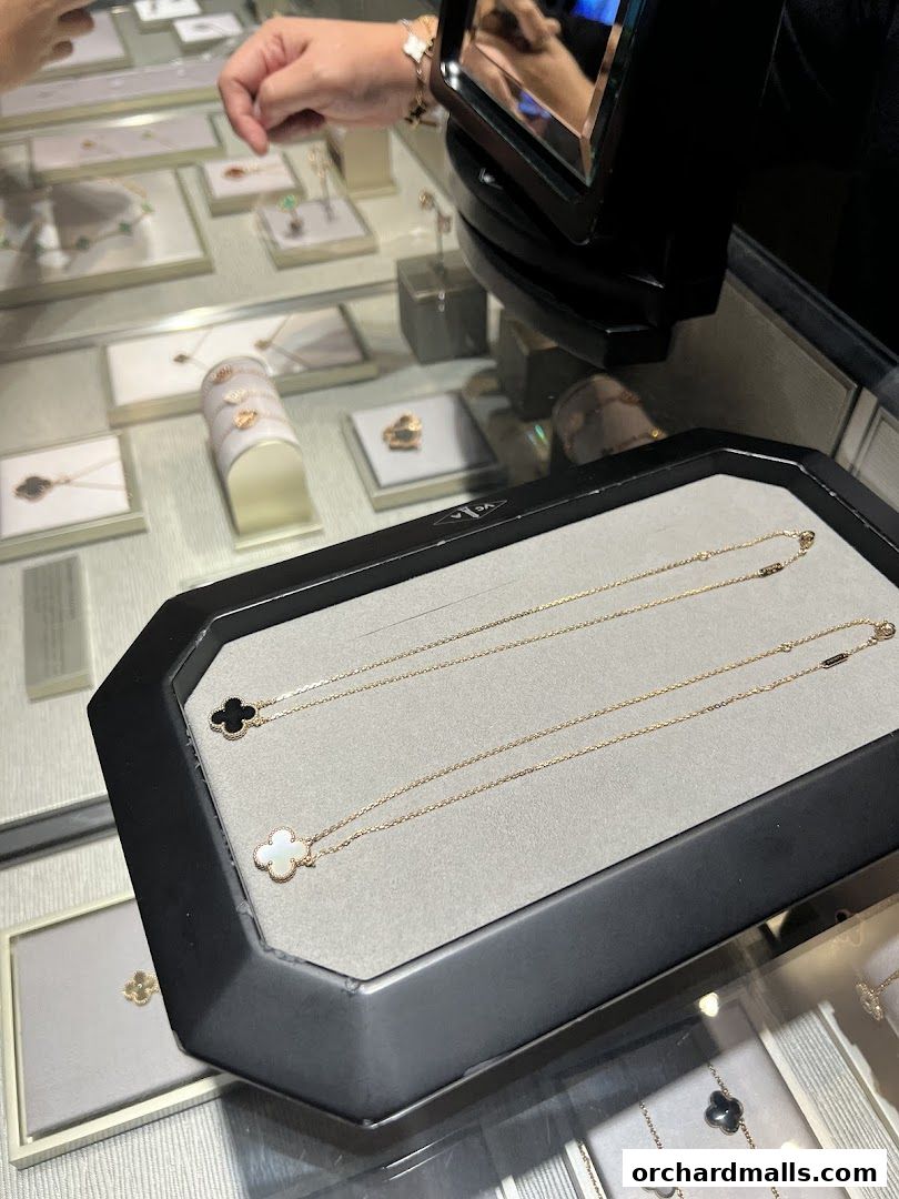Display of Van Cleef & Arpels necklaces and bracelets in a jewelry store display case.